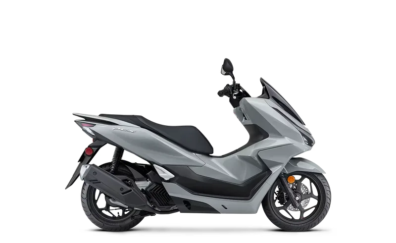 Light grey Honda PCX125 scooter with a black seat and alloy wheels, studio side view