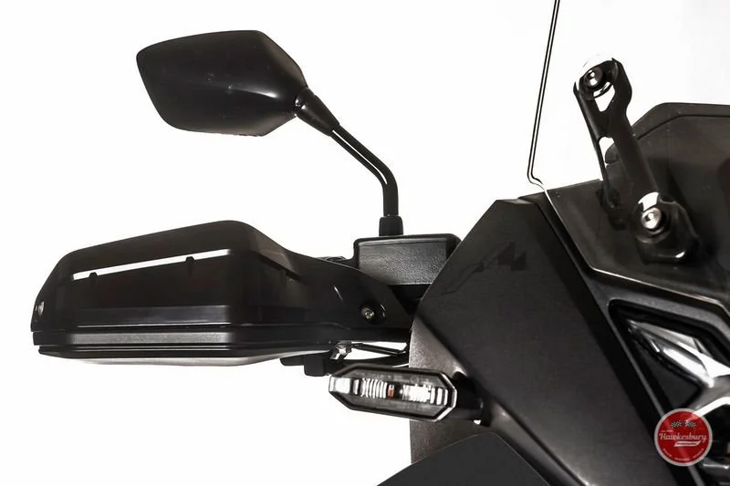 Motorcycle handlebar, side mirror and part of the dashboard with a storage compartment