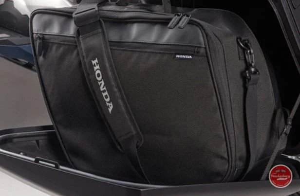 Black Honda-branded motorcycle bag in a storage compartment